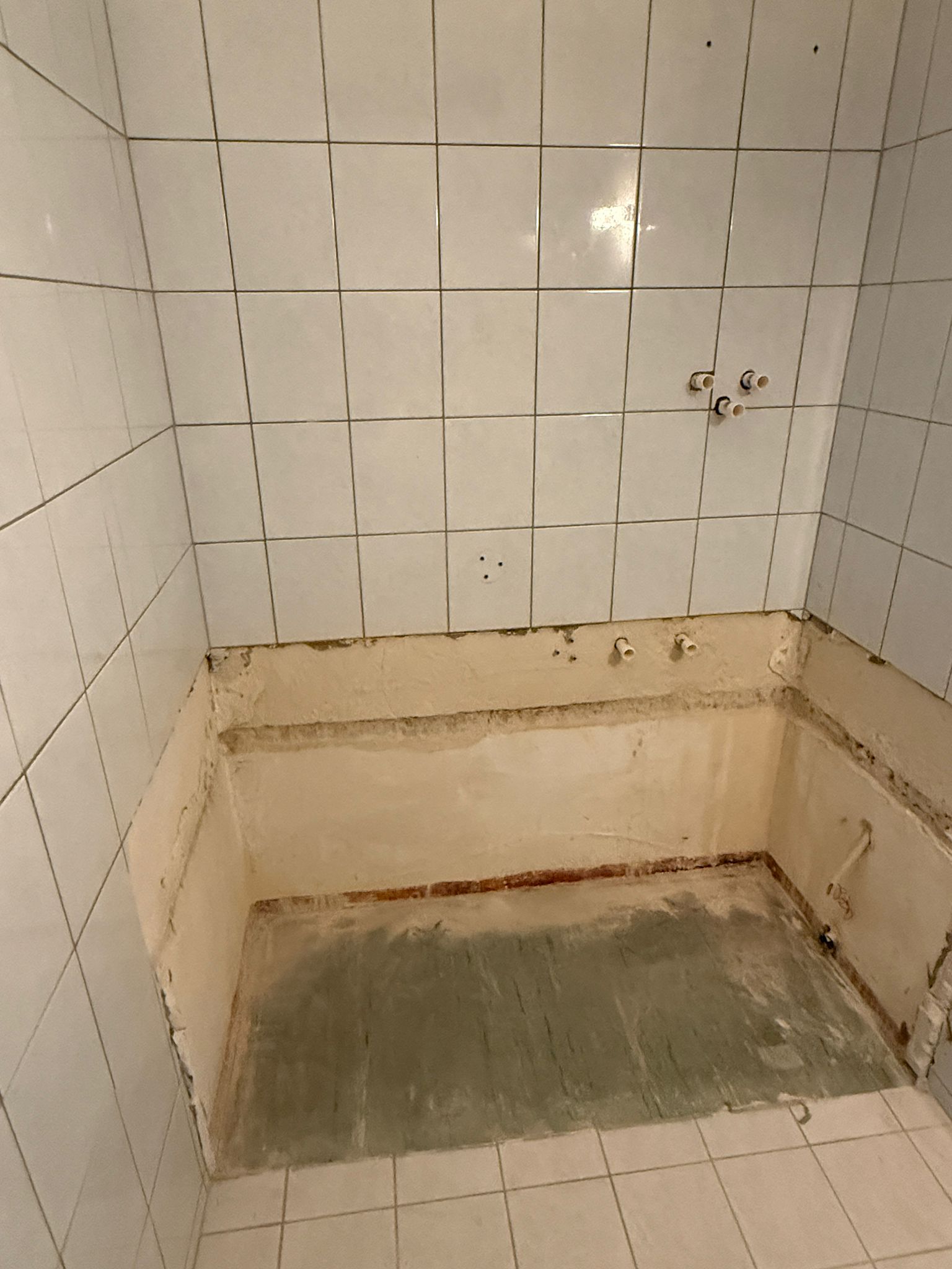 Alte Badewanne fachgerecht entfernt mit freigelegten Wasseranschlüssen für Dusche in Wien – Sanitärservice Wien