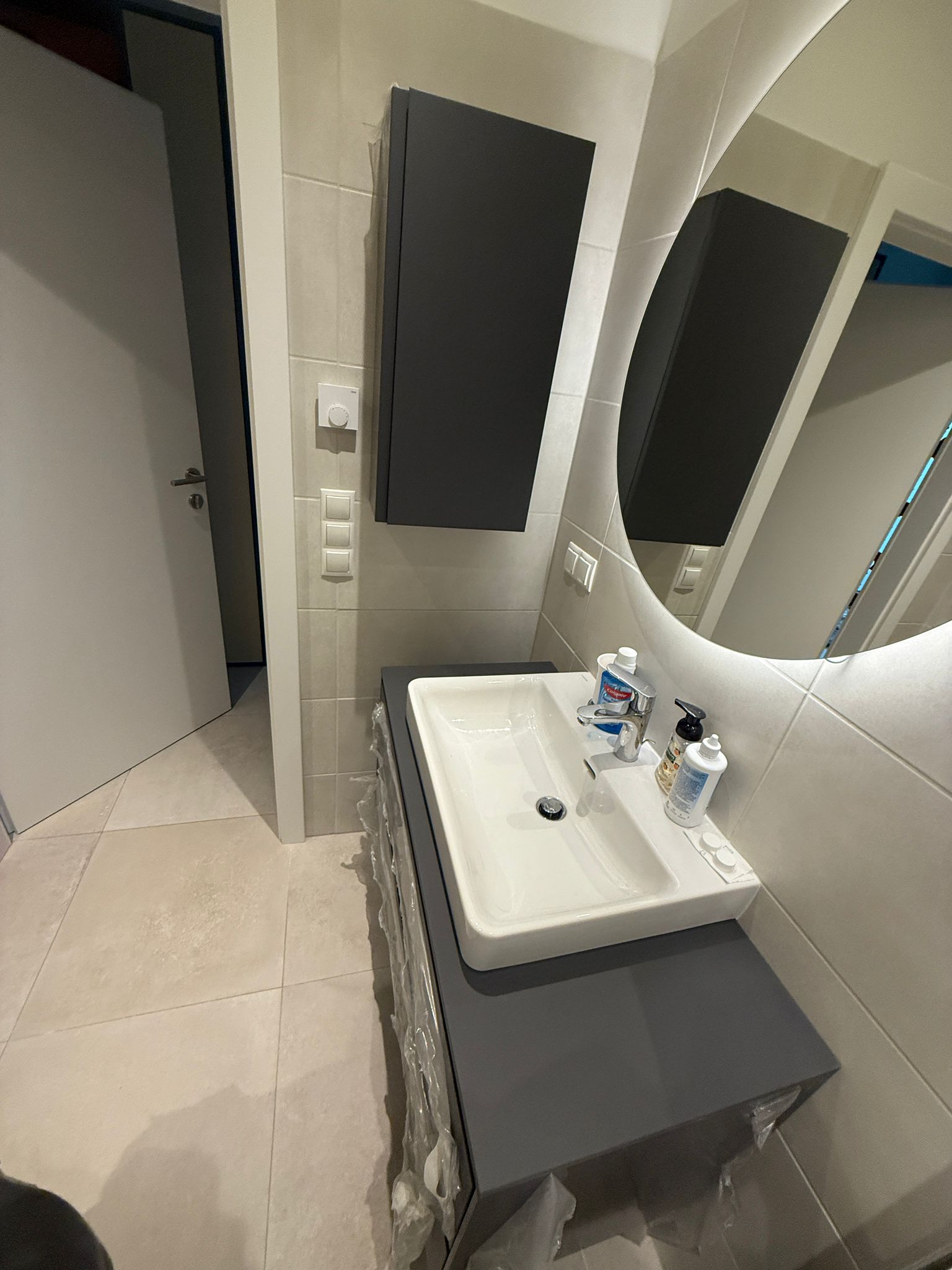 Montage von Design-Badmöbeln: Unterschrank, Oberschrank und runder Wandspiegel in Wien – Sanitärservice Wien